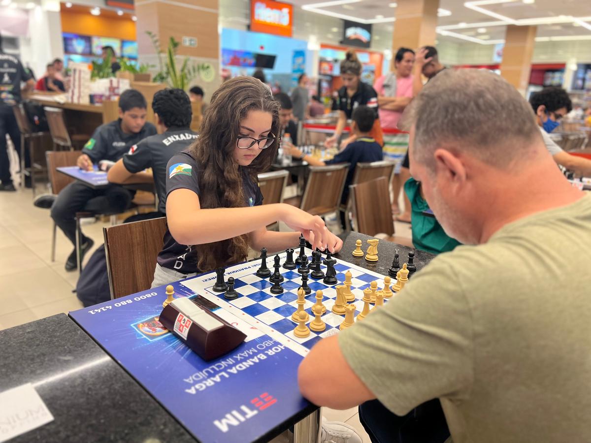 Os jogadores de xadrez masculinos começam a jogar, o primeiro movimento.  dois jogadores de xadrez começam o torneio intelectual dentro de casa.  tabuleiro de xadrez na mesa de madeira, jogo de estratégia
